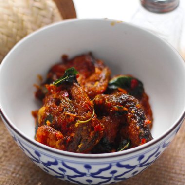 Baharatlı Kızarmış Yayın Balığı Tayland usulü beyaz bir masada servis edilir..