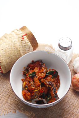 Baharatlı Kızarmış Yayın Balığı Tayland usulü beyaz bir masada servis edilir..