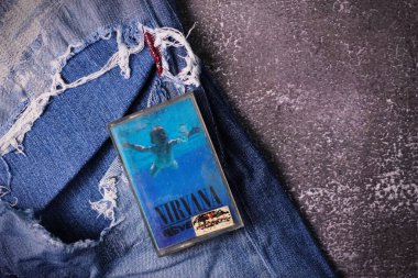 WASHINGTON, ABD - 30 Eylül 2022: Nirvana 'nın kaset kaseti ve yırtık kot pantolon veya yırtık kot pantolon. Grunge ya da Seattle sesinin sembolü..