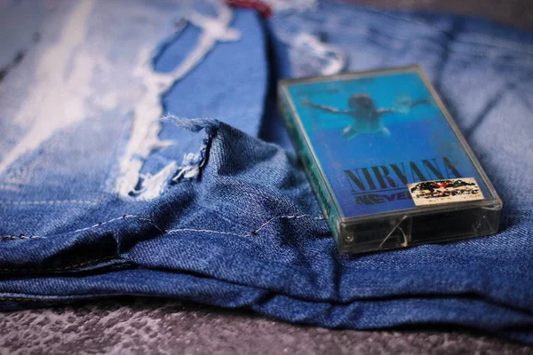 WASHINGTON, ABD - 30 Eylül 2022: Nirvana 'nın kaset kaseti ve yırtık kot pantolon veya yırtık kot pantolon. Grunge ya da Seattle sesinin sembolü..