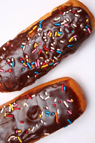 Chocolade Donut Bar Bekroond Met Veelkleurige Suikervlokken Gelegd Een Witte — Stockfoto