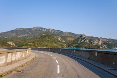 Bu manzara fotoğrafı Avrupa 'da, Fransa' da, Provence Alpes Cote dAzur 'da yaz mevsiminde çekilmiştir. Barrage de Castillon 'u geçen yolu görebiliyoruz, güneşin altında..