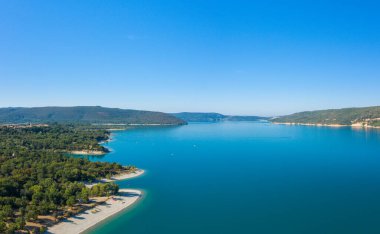 Bu manzara fotoğrafı Avrupa 'da, Fransa' da, Provence Alpes Cote dAzur 'da yaz mevsiminde çekilmiştir. Güneşin altındaki Sainte-Croix Gölü 'nün panoramik manzarasını görüyoruz..