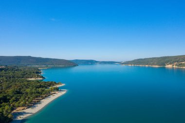 Bu manzara fotoğrafı Avrupa 'da, Fransa' da, Provence Alpes Cote dAzur 'da yaz mevsiminde çekilmiştir. Sainte-Croix Gölü 'nü dağların ve yeşil ormanların ortasında, güneşin altında görüyoruz..