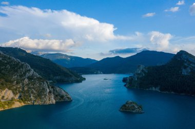 Bu manzara fotoğrafı Avrupa 'da, Fransa' da, Provence Alpes Cote dAzur 'da yaz mevsiminde çekilmiştir. Castillon Gölü 'nü ve dağların ortasında, güneşin altında kalan küçük adasını görüyoruz..