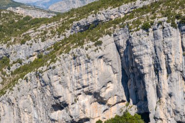 Bu manzara fotoğrafı Avrupa 'da, Fransa' da, Provence Alpes Cote dAzur 'da yaz mevsiminde çekilmiştir. Güneşin altındaki Verdon Boğazı 'nın kayalıklarını görüyoruz..
