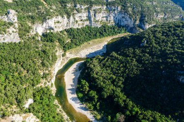 Bu manzara fotoğrafı Avrupa, Fransa, Ardeche, yaz aylarında çekildi. Ardeche Vadisi 'ni ve nehrini yeşil ormanların ortasında, güneşin altında görebiliyoruz..