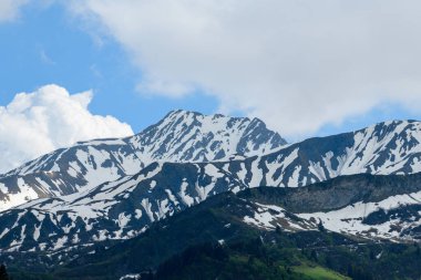 Bu manzara fotoğrafı Avrupa 'da, Fransa' da, Beaufort 'ta, Alpler' de, yazın çekildi. Orada dağların, güneşin altındaki ormanlara hakim olduğunu görüyoruz..