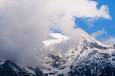 Bu manzara fotoğrafı Avrupa 'da, Fransa' da, Alpler 'de, yazın Chamonix' e doğru çekildi. Mont Blanc 'ı ve Aiguille du Gouter' ı gün batımında, güneşin altında bulutların altında saklanırken görüyoruz..