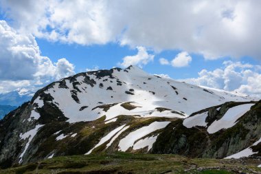 Bu manzara fotoğrafı Avrupa 'da, Fransa' da, Alpler 'de, yazın Chamonix' e doğru çekildi. Karla kaplı Aiguillette des Houches 'ı görüyoruz Bulutların altında Mont Blanc' ta, güneşin altında.