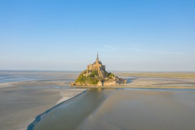 Bu manzara fotoğrafı ilkbaharda Avrupa, Fransa, Normandiya, Manche 'de çekildi. Le Mont-Saint-Michel 'i Manş Denizi' nin ortasında, güneşin altında görüyoruz..