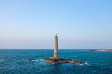Bu manzara fotoğrafı ilkbaharda Avrupa, Fransa, Normandiya, Manche 'de çekildi. Cap de la Hague deniz fenerini, dik kayalıklarında, güneşin altında görebiliriz..
