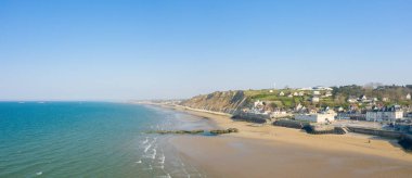 Bu manzara fotoğrafı yazın Avrupa, Fransa, Normandiya, Arromanches les Bains 'de çekildi. Arromanches les Bains kasabasının panoramik manzarasını görüyoruz. Alçak sularda, güneşin altında..