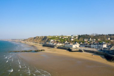Bu manzara fotoğrafı yazın Avrupa, Fransa, Normandiya, Arromanches les Bains 'de çekildi. Arromanches les Bains kasabasını görüyoruz, güneşin altında..