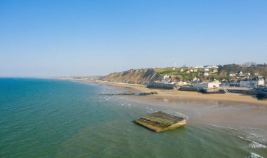 Bu manzara fotoğrafı yazın Avrupa, Fransa, Normandiya, Arromanches les Bains 'de çekildi. Arromanches les Bains şehrinin yapay limanını görebiliyoruz, güneşin altında..