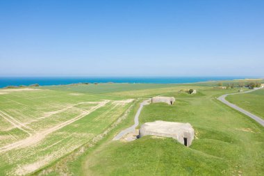 Bu manzara fotoğrafı Avrupa 'da, Fransa' da, Normandiya 'da, Arromanches' a karşı, Longues sur Mer 'de, ilkbaharda çekildi. Güneşin altındaki Longues-sur-Mer bataryalarının sığınaklarını görebiliyoruz..