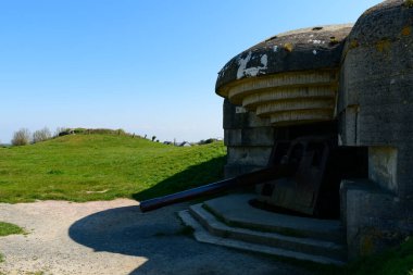 Bu manzara fotoğrafı Avrupa 'da, Fransa' da, Normandiya 'da, Arromanches' a karşı, Longues sur Mer 'de, ilkbaharda çekildi. Güneşin altında, Longues-sur-Mer bataryasından tahrip edilmiş bir top görüyoruz..
