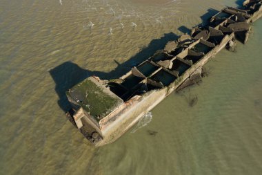 Bu manzara fotoğrafı yazın Avrupa, Fransa, Normandiya, Arromanches les Bains 'de çekildi. Asnelles 'deki yapay altın limanını görüyoruz. Yukarıda, güneşin altında..