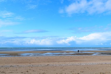 Bu manzara fotoğrafı yazın Avrupa, Fransa, Normandiya, Ouistreham 'da çekildi. Kanal Denizi 'nin önündeki kumsal bulutların altında, güneşin altında..