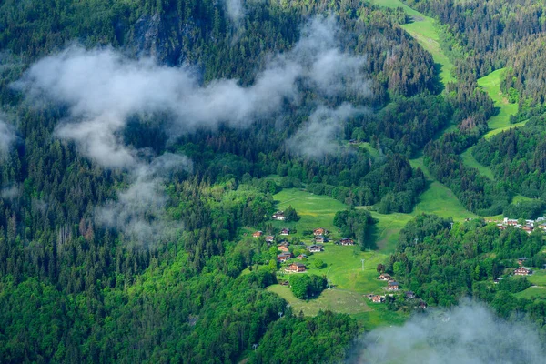 Bu manzara fotoğrafı Avrupa 'da, Fransa' da, Alpler 'de, yazın Chamonix' e doğru çekildi. Kırsal kesimde bulutlar görüyoruz ve yeşil ormanlar Mont Blanc Massif 'teki Les Houches' a doğru, güneşin altında..