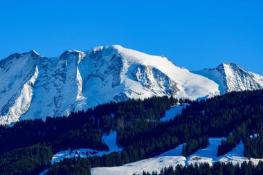 Bu manzara fotoğrafı Avrupa 'da, Fransa' da, Rhone Alpes 'te, Savoie' de, Alpler 'de, kışın çekildi. Ormanların ortasında, güneşin altında Les Domes de Miage 'i görüyoruz..