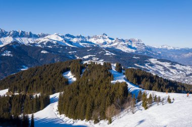 Bu manzara fotoğrafı Avrupa 'da, Fransa' da, Rhone Alpes 'te, Savoie' de, Alpler 'de, kışın çekildi. Megeve 'in kayak yamaçlarını Mont Blanc' ın dağlarının ortasında, güneşin altında görüyoruz..