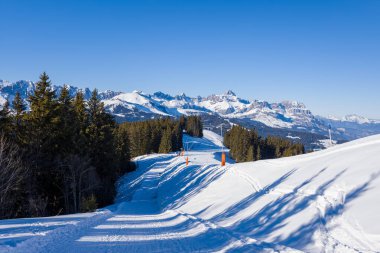 Bu manzara fotoğrafı Avrupa 'da, Fransa' da, Rhone Alpes 'te, Savoie' de, Alpler 'de, kışın çekildi. Megeve 'de Mont Blanc' ın dağlarının ortasında güneşin altında bir yürüyüş yolu görüyoruz..