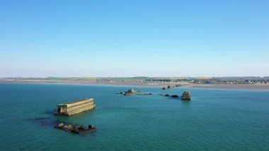 Arromanches, Asnelles 'e doğru, baharda güneşli bir günde Avrupa, Fransa ve Normandiya sahillerindeki yapay altın limanı.