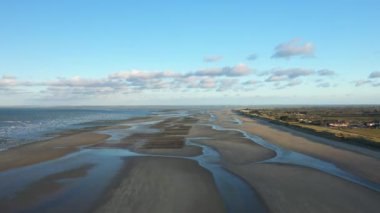 Bir traktör, güneşli bir günde Fransa 'nın Avrupa kırsalında bir tarla hasat eder..