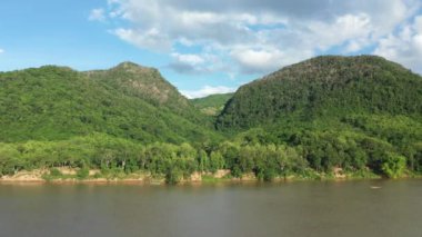 Asya 'da yeşil ormanları olan iki dağın önündeki Mekong nehri, Laos, yazın güneşli bir günde, Luang Prabang' a doğru..