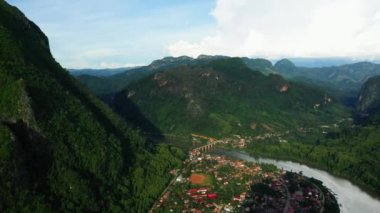 Nam Ou nehri kıyısındaki Nong Khiaw köyü Asya 'daki yeşil dağlarla çevrili, Laos, yazın güneşli bir günde, Luang Prabang' a doğru..