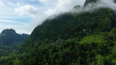 Muang Ngoi Neua 'daki dağların üzerinden Asya' daki Nong Khiaw 'a doğru bulutlar, Laos, güneşli bir yaz gününde Luang Prabang' a doğru..