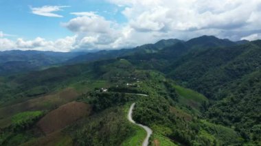 Yazın, güneşli bir günde, Vientiane ve Luang Prabang arasında, Asya 'daki yeşil dağların ve ormanların üzerinde bir yol Laos..
