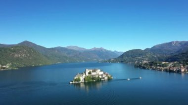 Orta Gölü 'nün ortasındaki Isola San Giulio adası yazın güneşli bir günde Avrupa, İtalya ve Piedmont' ta yeşil dağlarla çevrilidir..