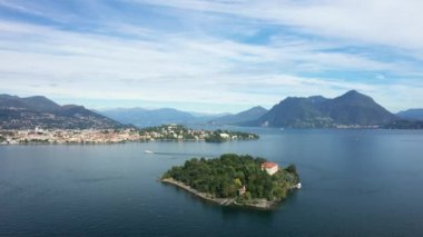 Isola Madre adası, yazın güneşli bir günde Avrupa, İtalya, Lombardy ve Piedmont 'ta Maggiore Gölü' nün yeşil kıyılarına bakıyor..