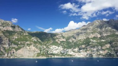 Yazın güneşli bir günde, Avrupa, İtalya ve Campania 'daki Tyrhenian Denizi kıyısındaki yeşil dağlara yerleşen Positano kasabası..