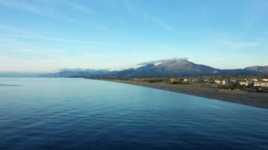 Acchio 'nun yüksek dağları - Fiumicello, güneşli bir yaz gününde Avrupa, İtalya ve Calabria' daki Tyrhenian Denizi kıyısındaki volkanik kumsala hakim olur..