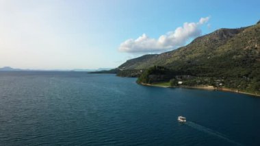 Yazın güneşli bir günde, Akdeniz 'de Avrupa, Yunanistan ve Epirus' un yeşil kırsalının kıyısında bir tekne yelken açar..