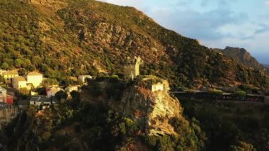 The village of Nonza in the middle of the arid and green mountains, in Europe, in France, in Corsica, towards Bastia, by the Mediterranean Sea, in summer, during a cloudy day.