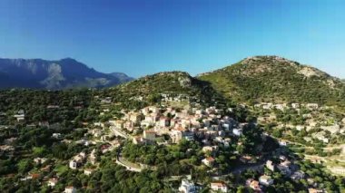Yeşil dağların üzerindeki Monticello köyü, Avrupa, Fransa, Korsika, Akdeniz kıyısında, güneşli bir günde,.