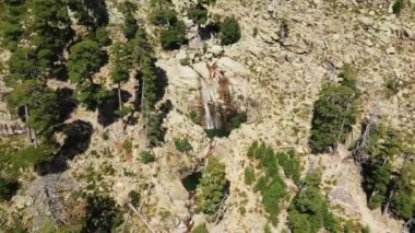The Cascades de Radule in the middle of the rocky and arid mountains, in Europe, in France, in Corsica, towards Ajaccio, by the Mediterranean Sea, in summer, on a sunny day.