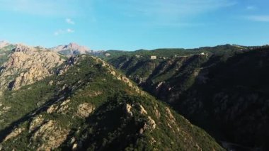 Dağlar ve yeşil ormanlar arasındaki çorak kırsal bölge, Avrupa 'da, Fransa' da, Korsika 'da, Ajaccio' ya doğru, Akdeniz kıyısında, yazın, güneşli bir günde.