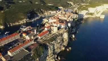The town of Bonifacio above the chalk cliffs in the green countryside , Europe, France, Corsica, towards Ajaccio, by the Mediterranean Sea, in summer, on a sunny day.