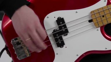 Bass player pulls the strings on the bass guitar, 4k 50fps