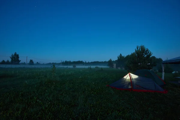 Geceleri tarlada parlayan çadır — Stok fotoğraf