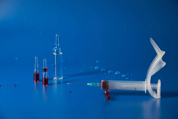 Syringe and medicines lie on blue background — Stock Photo, Image