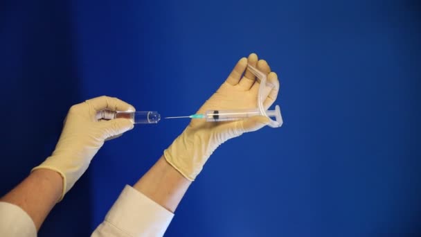 Guante de mano recogiendo la medicina sobre fondo azul — Vídeo de stock