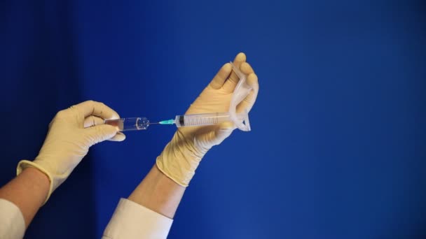 Guante de mano recogiendo la medicina sobre fondo azul — Vídeo de stock