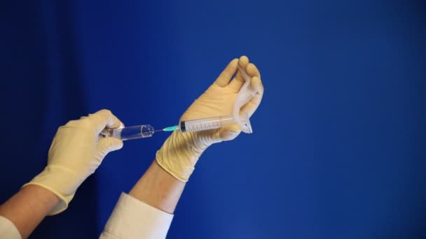 Guante de mano recogiendo la medicina sobre fondo azul — Vídeo de stock