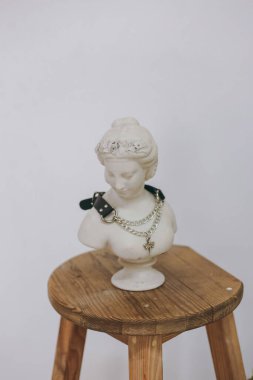 Deri ve zincirden yapılmış şık bir kolye alçı bir figürde asılı.